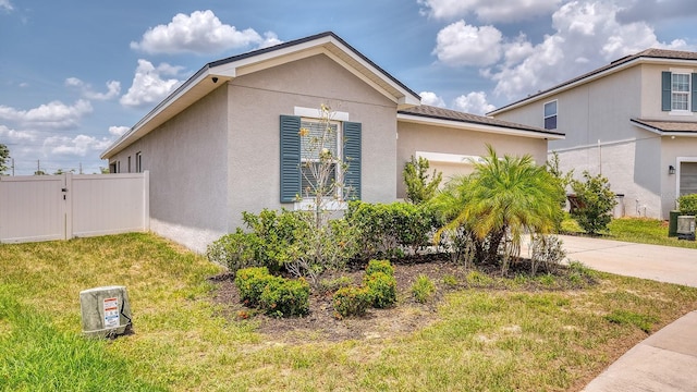 600 Buchannan Dr, Davenport, FL 33837 - view of side of property featuring concrete driveway, a garage, stucco siding, and central air condition unit