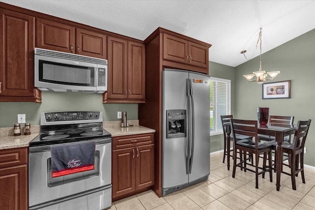 2344 Whispering Maple Dr, Orlando, FL 32837 - kitchen with appliances with stainless steel finishes, vaulted ceiling, light tile patterned floors, and baseboards