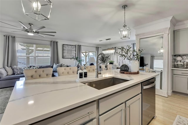 kitchen featuring open floor plan, a chandelier, a sink, and ornamental molding