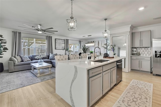kitchen featuring a sink, gray cabinets, appliances with stainless steel finishes, a chandelier, and decorative backsplash