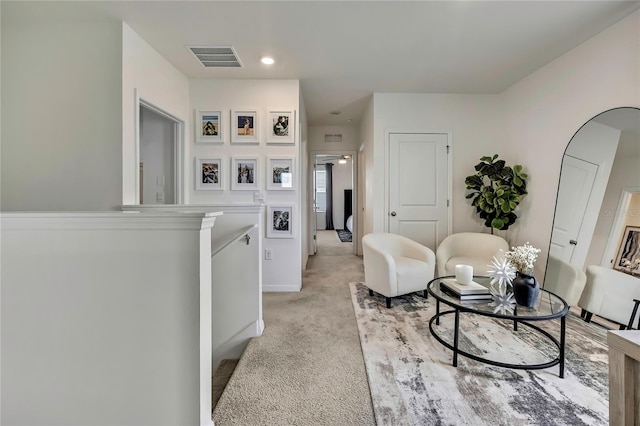 sitting room with light colored carpet, an upstairs landing, recessed lighting, and baseboards