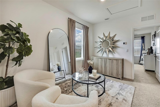 carpeted living room featuring attic access and baseboards