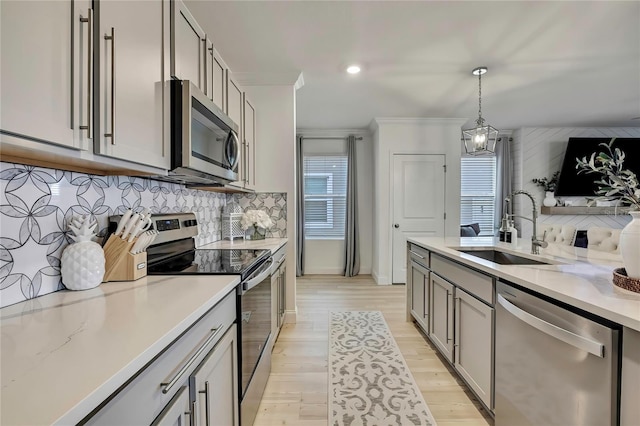 kitchen featuring stainless steel appliances, a sink, gray cabinetry, healthy amount of natural light, and recessed lighting