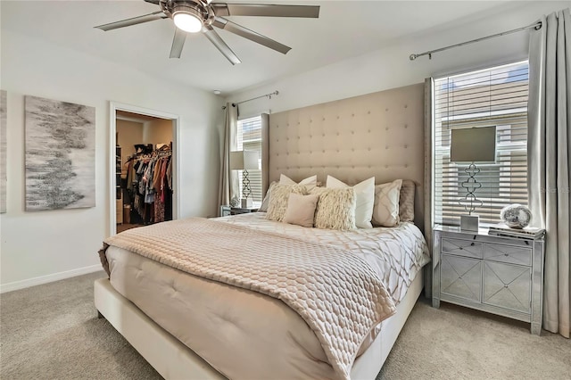 bedroom featuring carpet flooring, a walk in closet, a closet, baseboards, and a ceiling fan