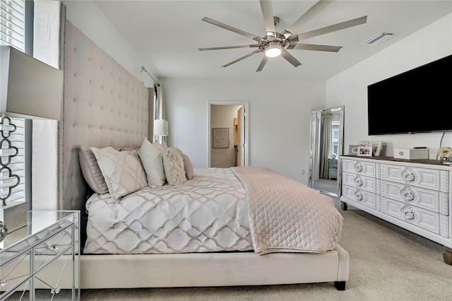 carpeted bedroom featuring ceiling fan and ensuite bathroom