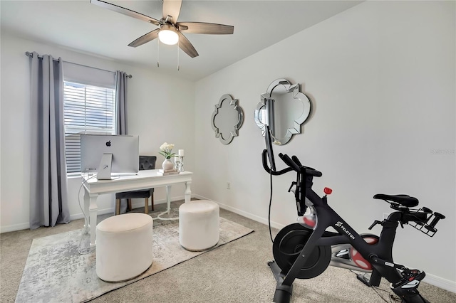 carpeted office space with ceiling fan and baseboards