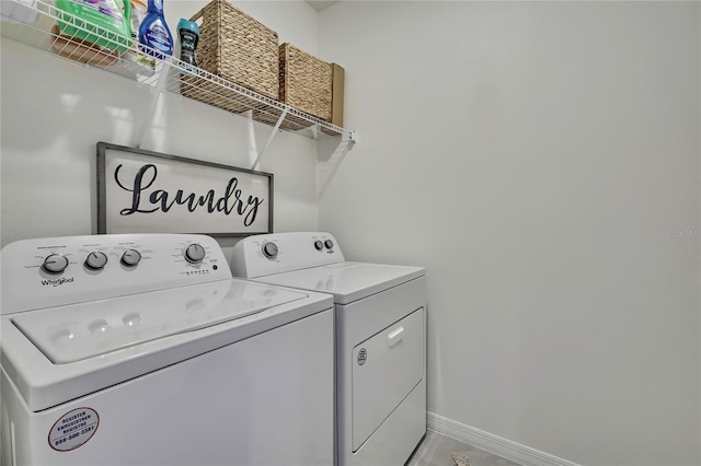 laundry area with washing machine and clothes dryer and baseboards