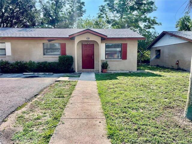 501 Las Palmas Cir Unit 676, Avon Park, FL 33825 - view of front facade featuring a front yard, stucco siding, roof with shingles, and asphalt driveway