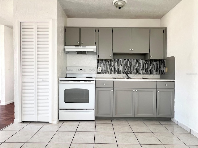 501 Las Palmas Cir Unit 676, Avon Park, FL 33825 - kitchen with gray cabinets, white electric range, under cabinet range hood, a sink, and a textured ceiling