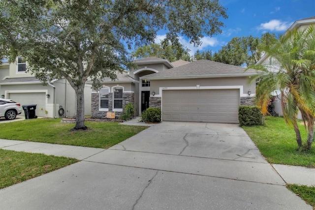10293 Cypress Knee Cir, Orlando, FL 32825 - view of front of house with stucco siding, concrete driveway, a front yard, an attached garage, and stone siding