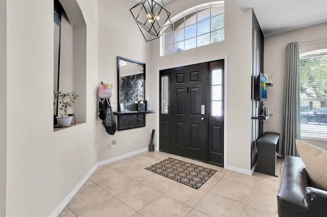 10293 Cypress Knee Cir, Orlando, FL 32825 - tiled foyer with baseboards, a chandelier, and a towering ceiling