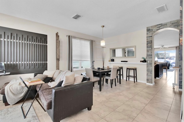 10293 Cypress Knee Cir, Orlando, FL 32825 - living area featuring light tile patterned flooring, arched walkways, and a ceiling fan