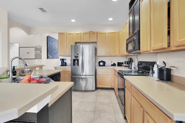 10293 Cypress Knee Cir, Orlando, FL 32825 - kitchen with black appliances, light brown cabinets, light countertops, recessed lighting, and arched walkways