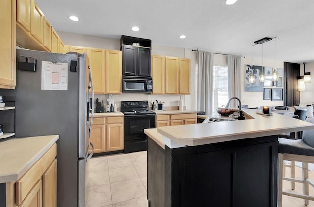 10293 Cypress Knee Cir, Orlando, FL 32825 - kitchen featuring black appliances, light brown cabinetry, a sink, a breakfast bar area, and a kitchen island with sink