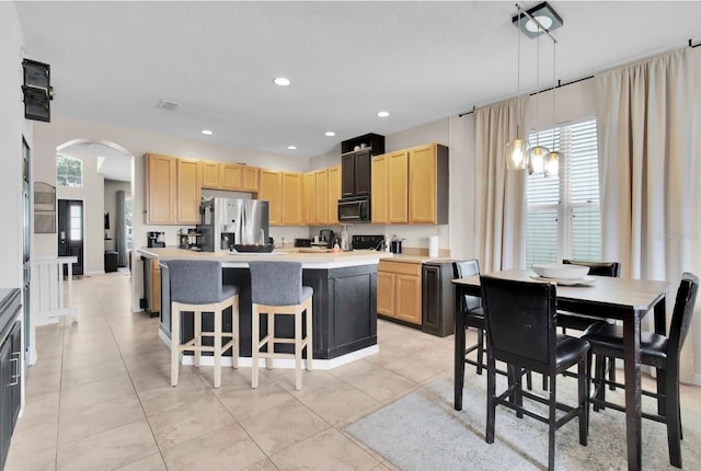 10293 Cypress Knee Cir, Orlando, FL 32825 - kitchen featuring black appliances, arched walkways, light brown cabinets, healthy amount of natural light, and recessed lighting