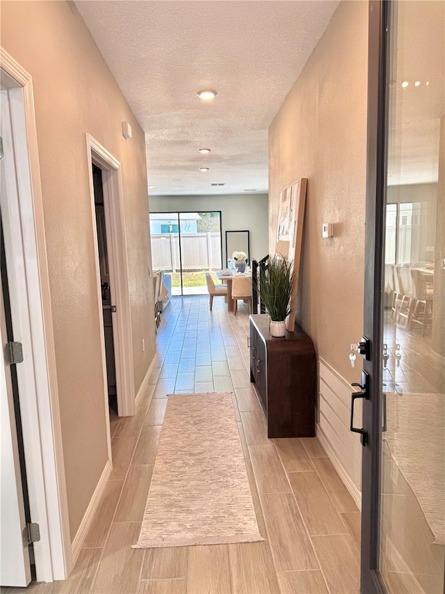 107 Grove St, Orlando, FL 32835 - hall with wood finish floors, a textured ceiling, and baseboards