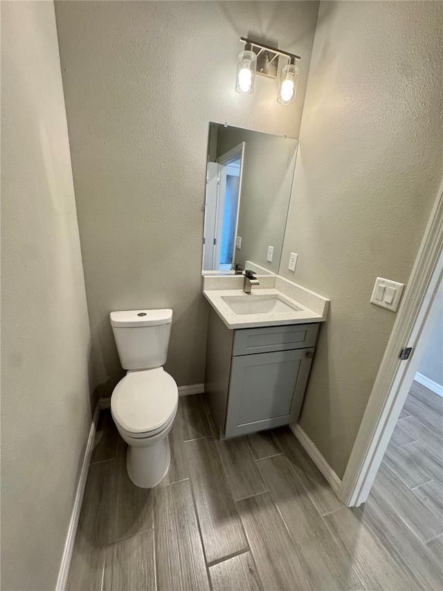 107 Grove St, Orlando, FL 32835 - bathroom featuring wood finished floors, vanity, toilet, and baseboards