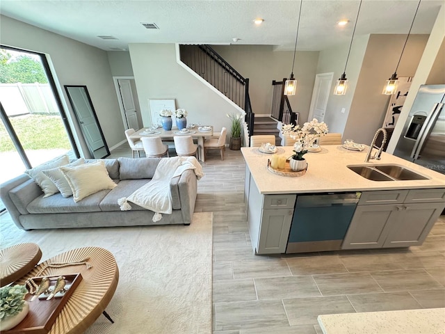 107 Grove St, Orlando, FL 32835 - kitchen featuring gray cabinets, dishwashing machine, a sink, light countertops, and open floor plan