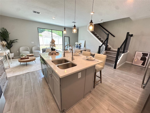 107 Grove St, Orlando, FL 32835 - kitchen featuring a sink, gray cabinetry, open floor plan, light wood-type flooring, and a textured ceiling