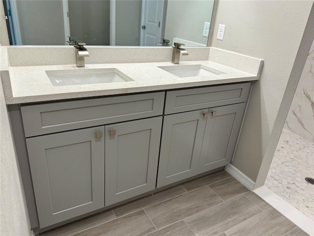 107 Grove St, Orlando, FL 32835 - full bathroom featuring double vanity, a shower, baseboards, and wood finish floors