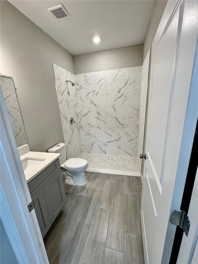 107 Grove St, Orlando, FL 32835 - full bathroom featuring vanity, a marble finish shower, toilet, and wood tiled floors