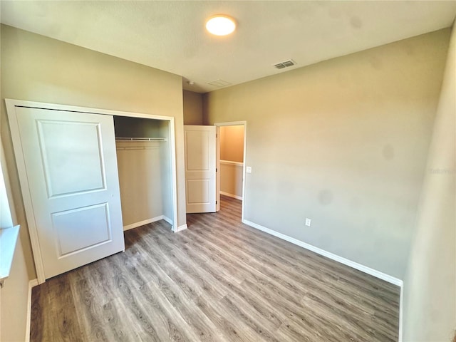 107 Grove St, Orlando, FL 32835 - unfurnished bedroom with wood finished floors, baseboards, and a closet