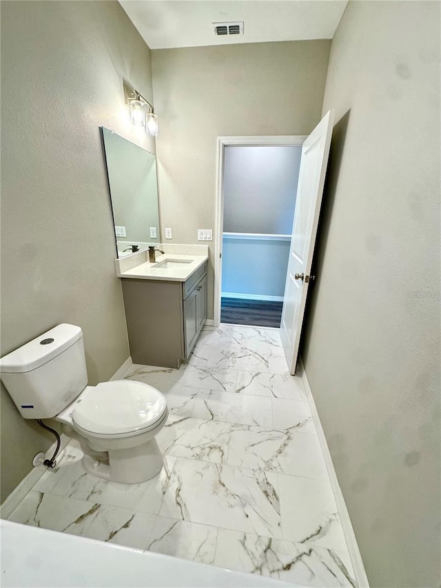 107 Grove St, Orlando, FL 32835 - bathroom featuring toilet, baseboards, vanity, and marble look tiles