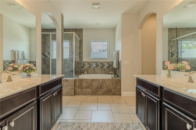 8268 Bellow St, Orlando, FL 32827 - full bathroom featuring two vanities, a shower stall, a garden tub, and tile patterned floors