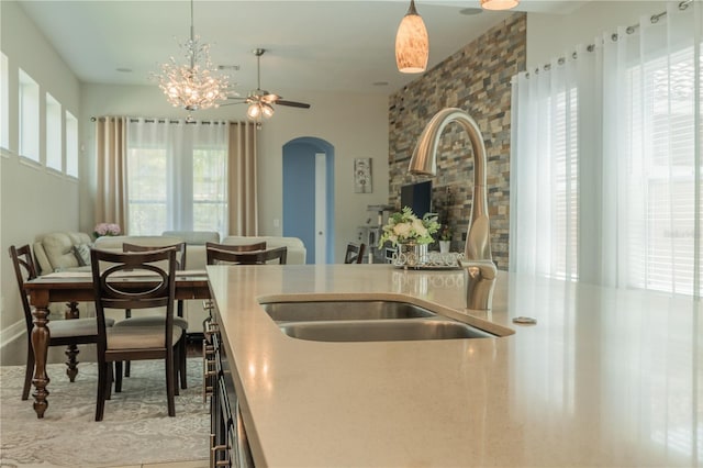8268 Bellow St, Orlando, FL 32827 - kitchen featuring a sink, arched walkways, decorative light fixtures, a chandelier, and light countertops