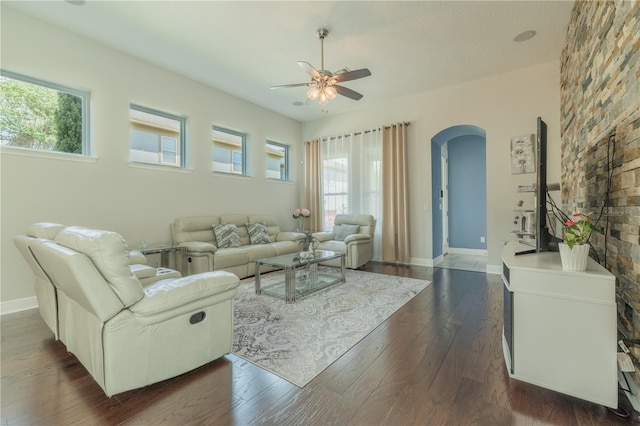 8268 Bellow St, Orlando, FL 32827 - living room featuring arched walkways, a ceiling fan, healthy amount of natural light, and dark wood-type flooring