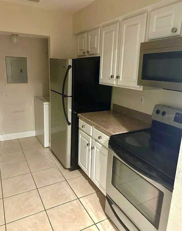 3772 Idlebrook Cir Unit 100, Casselberry, FL 32707 - kitchen featuring stainless steel appliances, electric panel, light tile patterned floors, washer / dryer, and white cabinetry