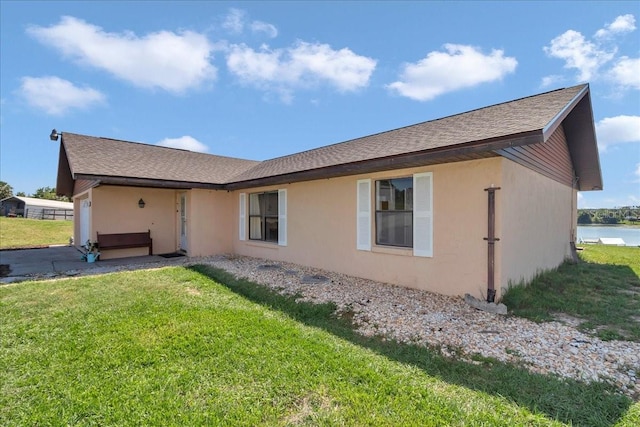 16386 SE 156th Place Rd, Weirsdale, FL 32195 - back of property featuring a yard, roof with shingles, and stucco siding