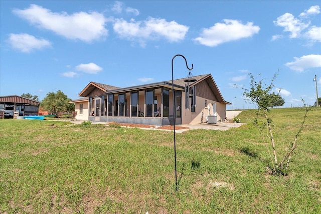 16386 SE 156th Place Rd, Weirsdale, FL 32195 - back of house with a sunroom, a yard, and central AC unit