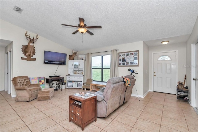 16386 SE 156th Place Rd, Weirsdale, FL 32195 - living room featuring a ceiling fan, light tile patterned floors, a textured ceiling, vaulted ceiling, and baseboards