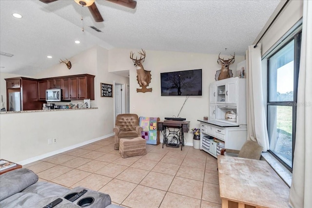 16386 SE 156th Place Rd, Weirsdale, FL 32195 - living area featuring a textured ceiling, a ceiling fan, lofted ceiling, light tile patterned flooring, and baseboards