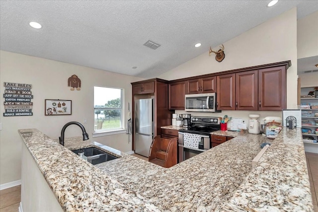 16386 SE 156th Place Rd, Weirsdale, FL 32195 - kitchen featuring appliances with stainless steel finishes, a sink, a textured ceiling, lofted ceiling, and light stone countertops