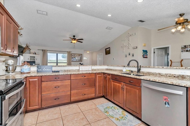 16386 SE 156th Place Rd, Weirsdale, FL 32195 - kitchen with stainless steel appliances, a ceiling fan, a sink, vaulted ceiling, and brown cabinets