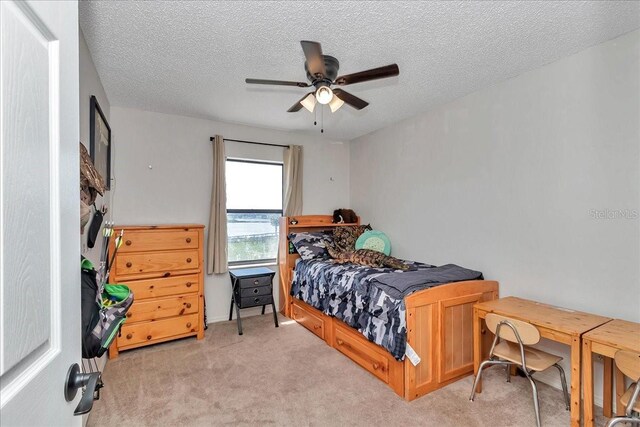 16386 SE 156th Place Rd, Weirsdale, FL 32195 - bedroom with light colored carpet, a textured ceiling, and a ceiling fan