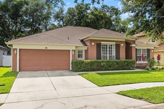 356 Via Tuscany Loop, Lake Mary, FL 32746 - ranch-style house with stucco siding, a front lawn, an attached garage, and driveway