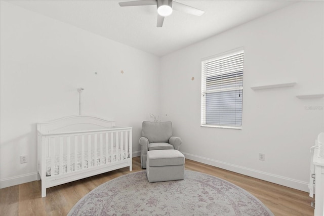 356 Via Tuscany Loop, Lake Mary, FL 32746 - bedroom featuring baseboards, wood finished floors, a nursery area, and ceiling fan