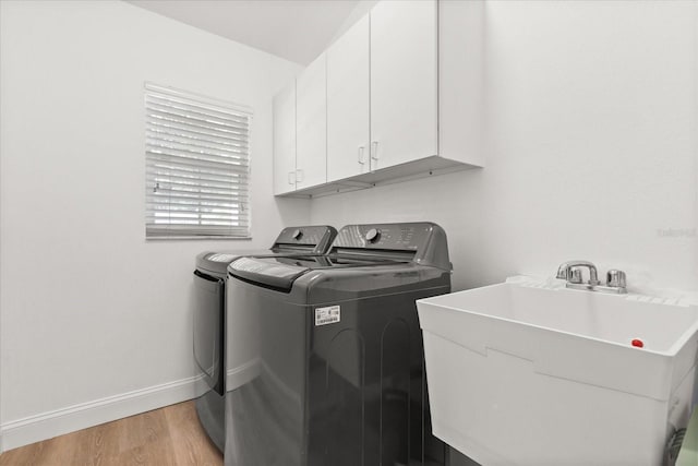 356 Via Tuscany Loop, Lake Mary, FL 32746 - laundry area with washing machine and clothes dryer, cabinet space, light wood-style floors, and baseboards
