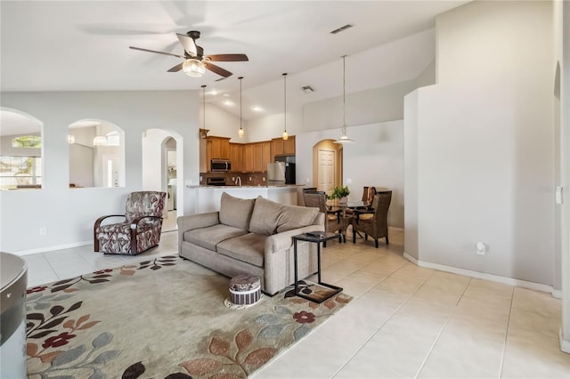 2481 Deer Creek Blvd, Saint Cloud, FL 34772 - living area with lofted ceiling, light tile patterned flooring, arched walkways, ceiling fan, and baseboards