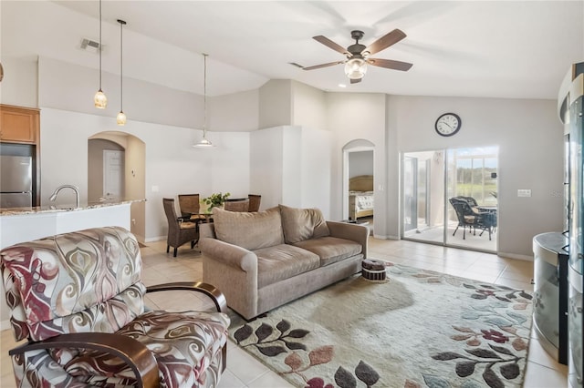 2481 Deer Creek Blvd, Saint Cloud, FL 34772 - living room with arched walkways, light tile patterned floors, high vaulted ceiling, a ceiling fan, and baseboards