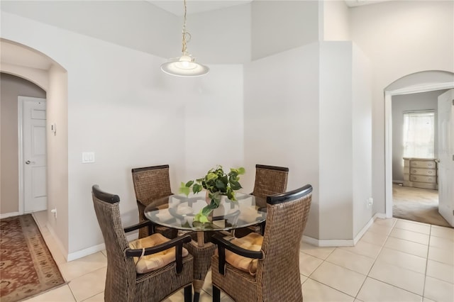 2481 Deer Creek Blvd, Saint Cloud, FL 34772 - dining room featuring arched walkways, light tile patterned flooring, a towering ceiling, and baseboards