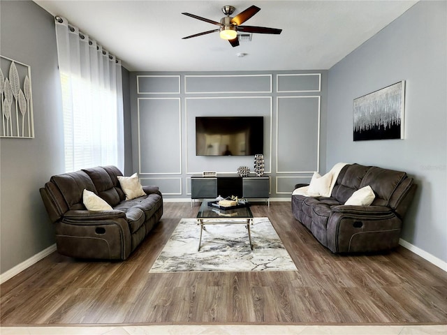236 Boxwood Dr, Davenport, FL 33837 - living room featuring a ceiling fan, wood finished floors, a decorative wall, and baseboards