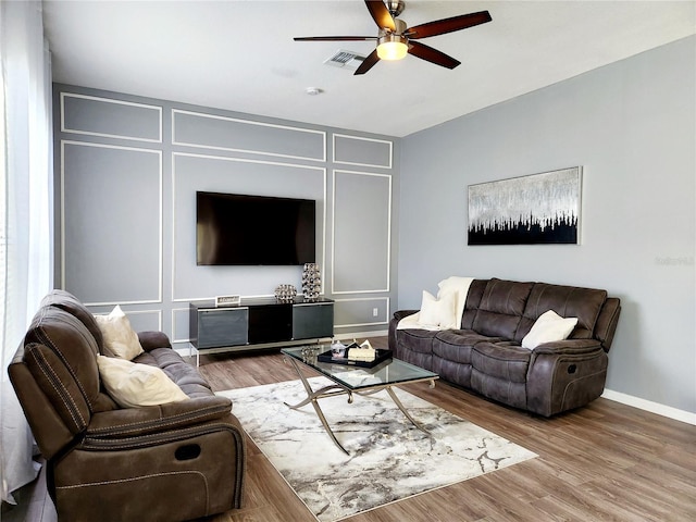 236 Boxwood Dr, Davenport, FL 33837 - living room featuring a decorative wall, ceiling fan, baseboards, and wood finished floors