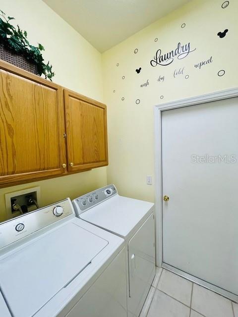 236 Boxwood Dr, Davenport, FL 33837 - laundry room with cabinet space, washer and clothes dryer, and light tile patterned floors