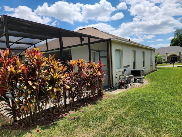 236 Boxwood Dr, Davenport, FL 33837 - view of home's exterior featuring a yard, glass enclosure, stucco siding, and central AC