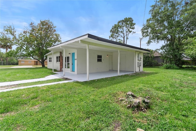 5115 W Livingston St, Orlando, FL 32811 - back of property with a lawn, an attached carport, and a patio
