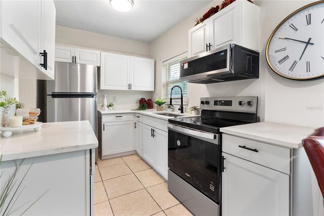 5115 W Livingston St, Orlando, FL 32811 - kitchen with stainless steel appliances, white cabinets, and light tile patterned floors